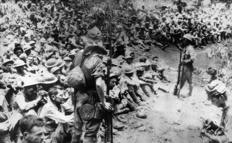 In this 1942 file photo provided by U.S. Marine Corps, Japanese soldiers stand guard over American war prisoners just before the start of the Bataan Death March following the Japanese occupation of the Philippines.