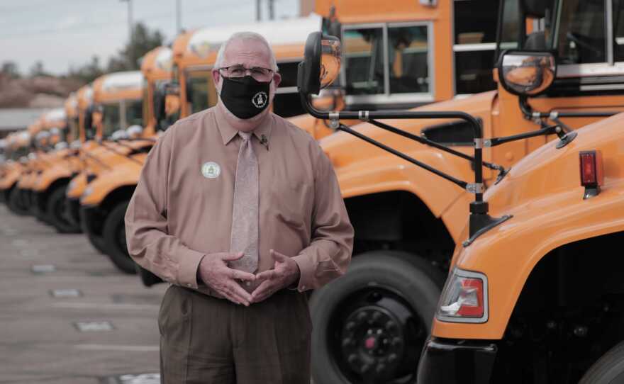 Tim Purvis, transportation director at Poway Unified School District, stands in front of a fleet of buses at the district's transportation center.