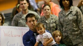Chris Phelan, with his daughter River, prepares to greet his wife, Star Lopez, upon her arrival home from serving in Afghanistan.
