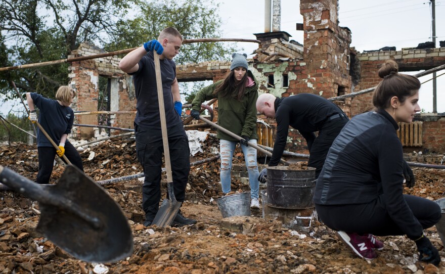 Repair Together volunteers work to clean up the home of Hanna Yurchenko in Kolychivka on Oct. 1.