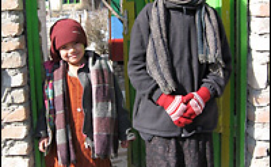 Fariya, 6, and her sister Parisa, 11, stand at the entrance to the Afghan Mobile Mini Circus compound.