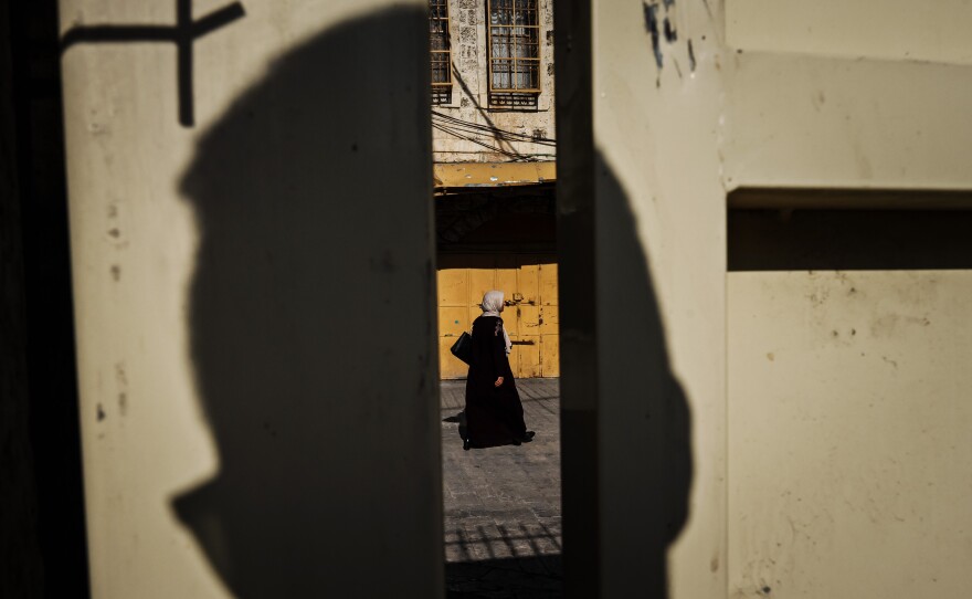 A woman walks by on the Palestinian-designated side as seen from the Israeli settlement enclave side of the Old City of Hebron on Nov. 5.