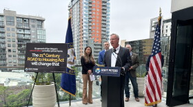 Rep. Scott Peters, D-San Diego, speaks at a media event highlighting the importance of the 21st Century ROAD to Housing Act. Behind him are Carlynne Yu, CFO of the Regional Task Force on Homelessness; James Silverwood, President of Affirmed Housing; and Stephen Russel, President and CEO of the San Diego Housing Federation.