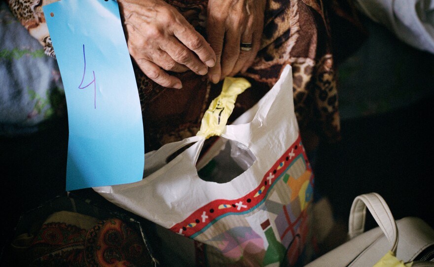 The Ukrainian Red Cross prepares a patient for medical evacuation from Sloviansk hospital. To keep track of evacuees and their belongings, everyone is issued a numbered tag that matches the patient's luggage. June 2022.