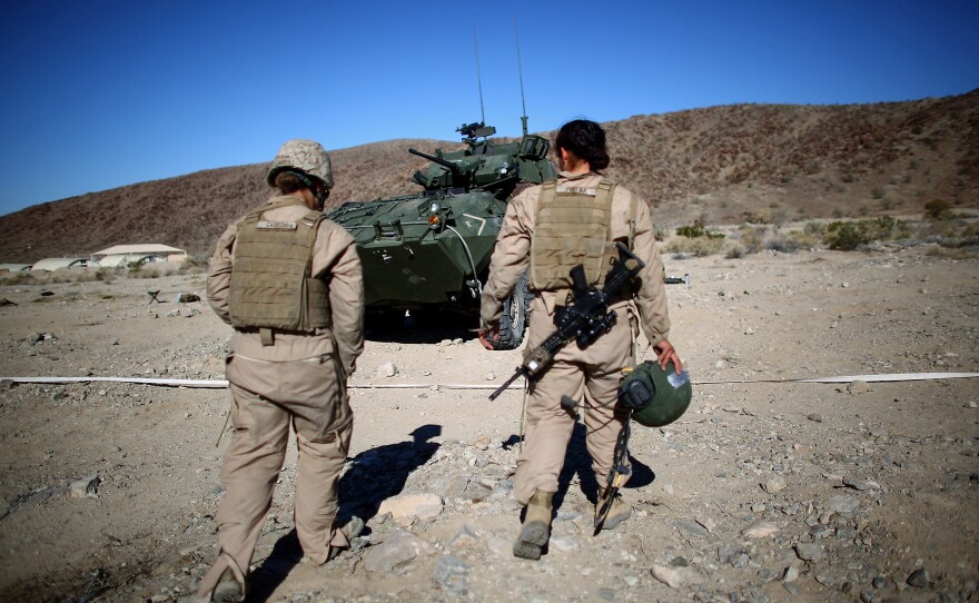 Marine Lance Cpls. Julia Carroll (left) and Paula Pineda walk back to their LAV after a test to check their skills.