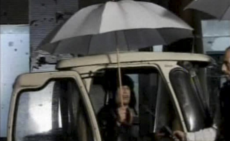 In this video image broadcast on Libyan state television early Tuesday, leader Moammar Gadhafi is shown. Gadhafi appeared for less than a minute on state television and made brief remarks to say he was in the capital Tripoli and deny rumors he had to fled to Venezuela amid the unrest sweeping his country.