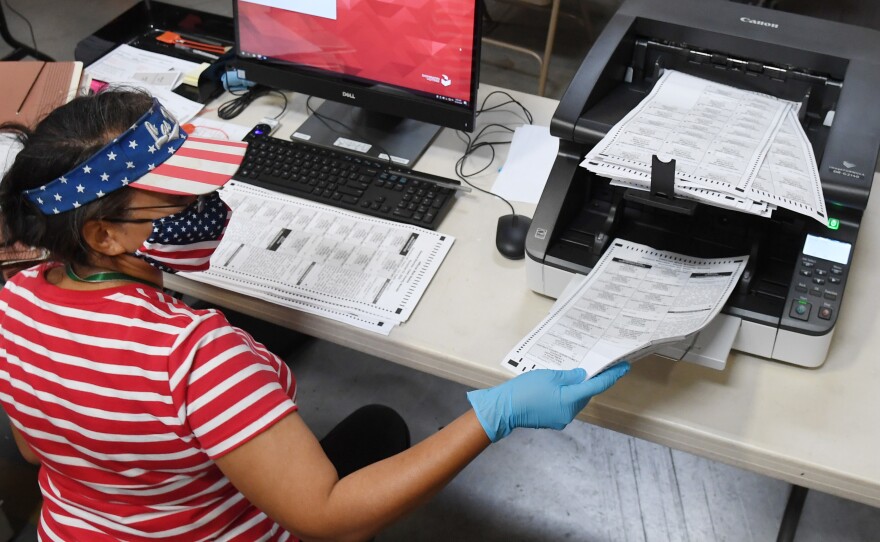 A Clark County, Nev. election worker scans mail-in ballots on October 20, 2020 in North Las Vegas. Nevada allows officials to count ballots received in advance of Election Day in order to speed the tabulation of results that evening.