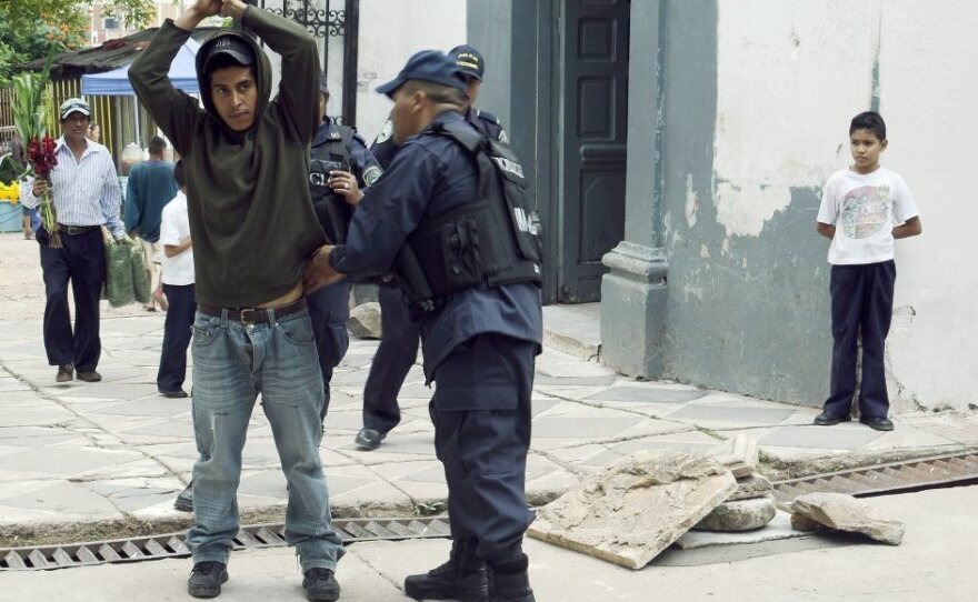 A police officer frisks a man as part of Operation Lightning, an initiative that seeks to stop violence in Honduras, in Tegucigalpa, on Nov. 1.