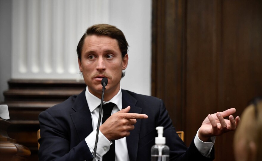 Richard "Richie" McGinniss, chief video director for The Daily Caller, shows how Kyle Rittenhouse was holding his rifle before he shot Joseph Rosenbaum as he gives testimony during Rittenhouse's trial at the Kenosha County Courthouse in Kenosha, Wis., on Thursday, Nov. 4.