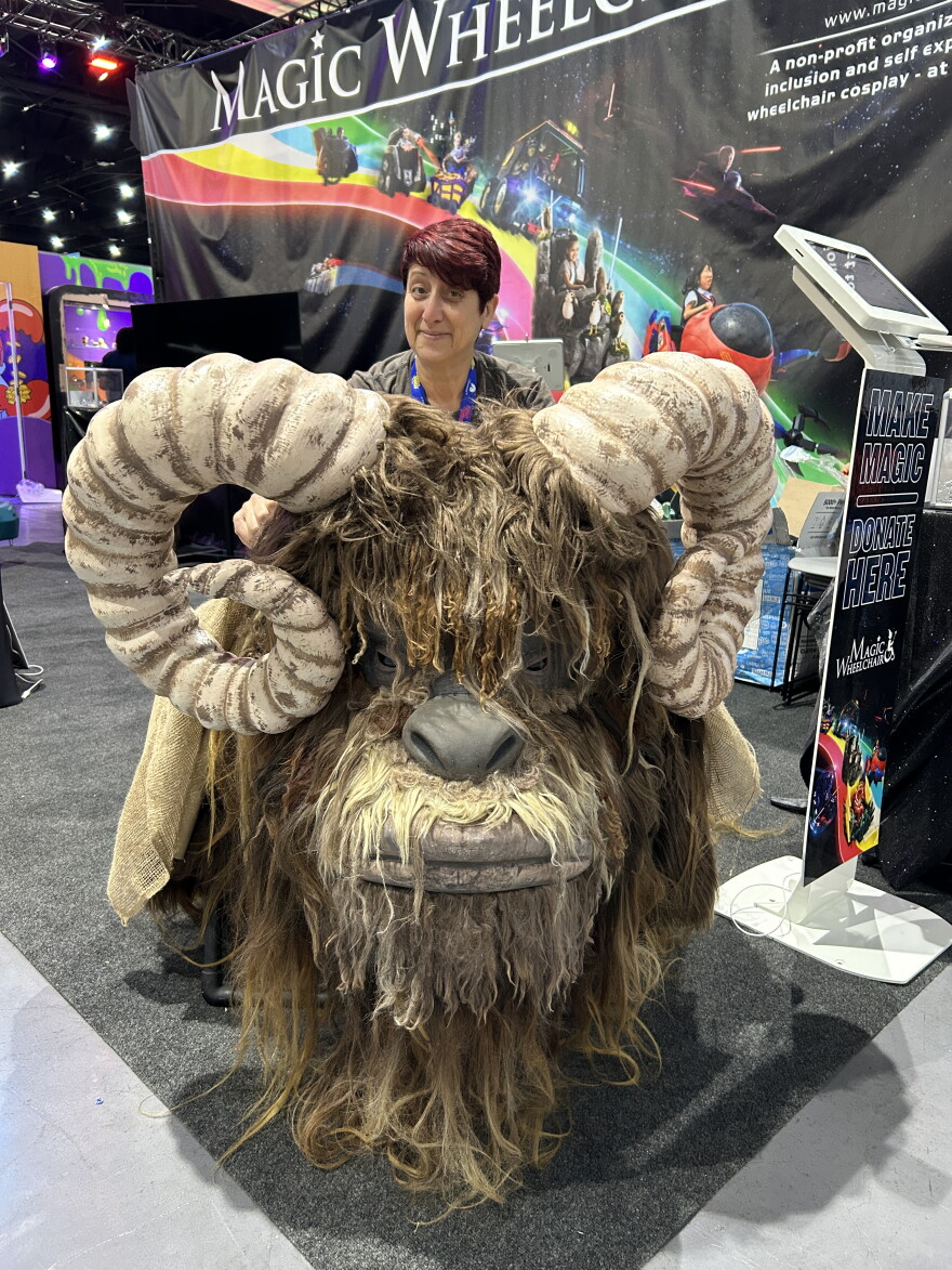 KPBS arts reporter Beth Accomando visits the Magic Wheelchair booth at Comic-Con and admires a Bantha costume created for children who use wheelchairs on July 22, 2026.