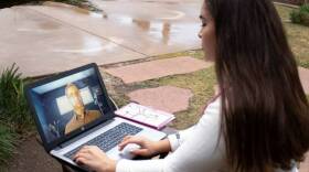 Alexis Hawkins, a nursing student at Grossmont College in El Cajon, views an instructional video in the front yard of her home. Hawkins has been practicing her skills on family members while learning from home. 