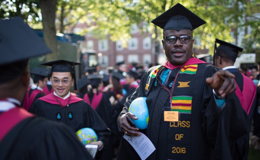 Gregory "Buster" Coleman in his cap and gown. Each graduate of the Kennedy School of Government carried an inflatable globe.