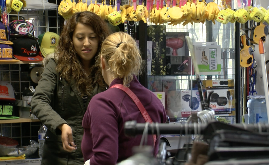 A cashier returns change at Carolin Shoes Inc. at Abbys Wholesale and Retail in San Ysidro, Feb. 20, 2017.