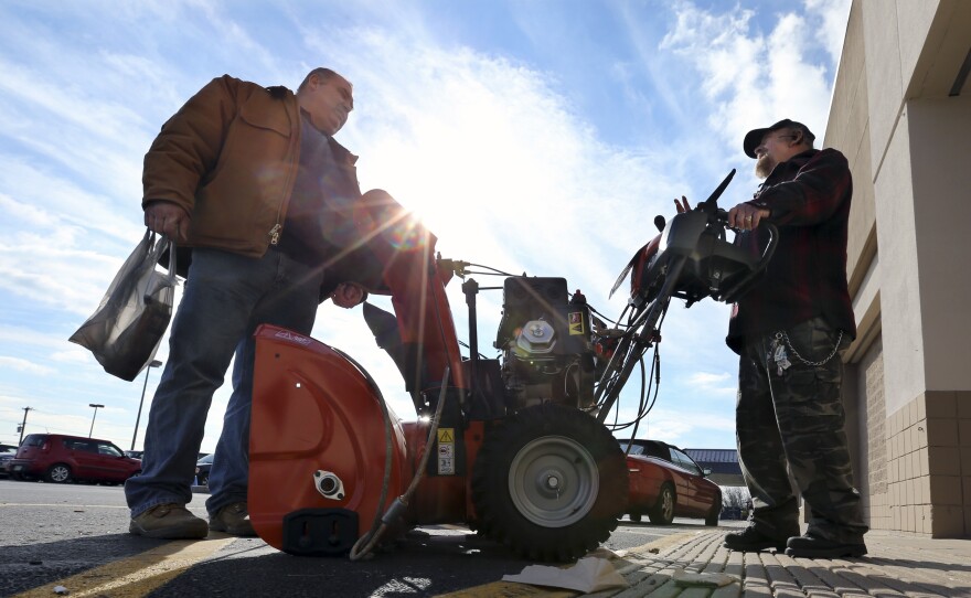 Two men discuss the pros and cons of various snowblowers outside a Lowe's home improvement warehouse Thursday in Langhorne, Pa. The northern mid-Atlantic region, including Baltimore, Washington and Philadelphia, is preparing for a weekend snowstorm that is now forecast to reach blizzard conditions.
