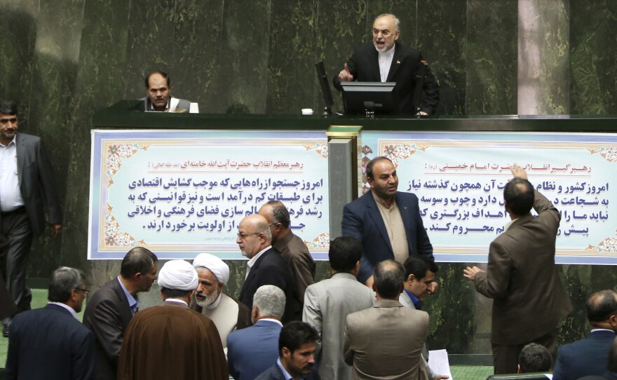 Ali Akbar Salehi, top, the head of Iran's Atomic Energy Organization, delivers a speech as lawmakers and officials discuss a bill on Iran's nuclear deal in parliament on Sunday. The parliament approved an outline of a bill allowing the deal's implementation.