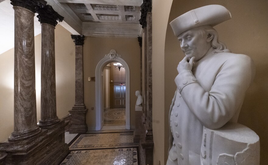 A statue of Benjamin Franklin is seen in an empty corridor outside the Senate at the Capitol in Washington, Thursday, Dec. 27, 2018, during a partial government shutdown.