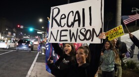 In this Nov. 21, 2020, file photo, demonstrators shout slogans while carrying a sign calling for a recall on Gov. Gavin Newsom during a protest against a stay-at-home order amid the COVID-19 pandemic in Huntington Beach, Calif. 