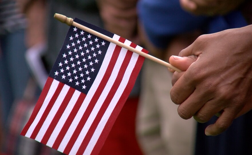 An attendee at a Memorial Day ceremony in Coronado holds a flag, May 30, 2016.