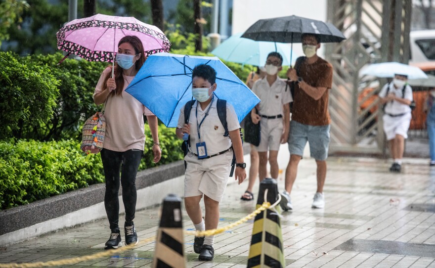 Children arrive at Hong Kong's Maryknoll Fathers' Primary School on June 8, the first day of classes since the COVID-19 outbreak.