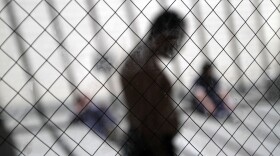 Men sit in the sun in the health ward at the Otay Mesa immigration detention center in San Diego, May 26, 2010. 