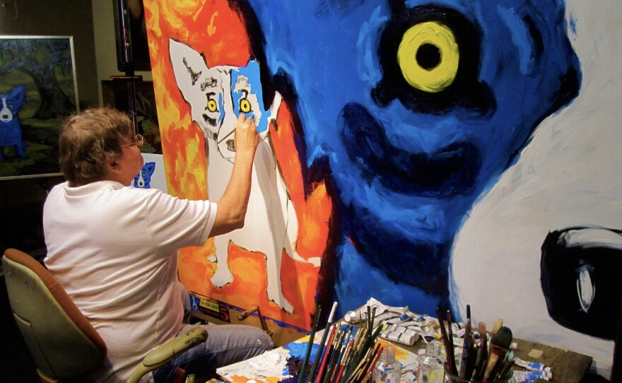Artist George Rodrigue working on one of his iconic Blue Dog paintings.
