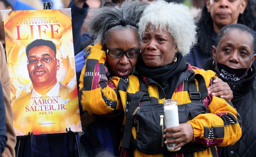 People participate in a vigil to honor the 10 people killed in Saturday's shooting at Tops market in Buffalo, New York.
