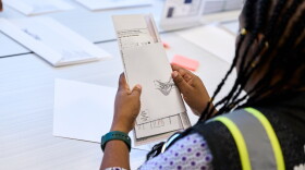 A Wake County Board of Elections employee prepares a mail-in ballot to be sent out to a voter in September in Raleigh, N.C.