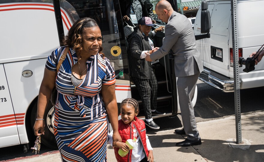 Lora King, daughter of Rodney King and CEO of the Rodney King Foundation, and her son, Raymond Price, 2, exit a tour bus before the start of the press conference.