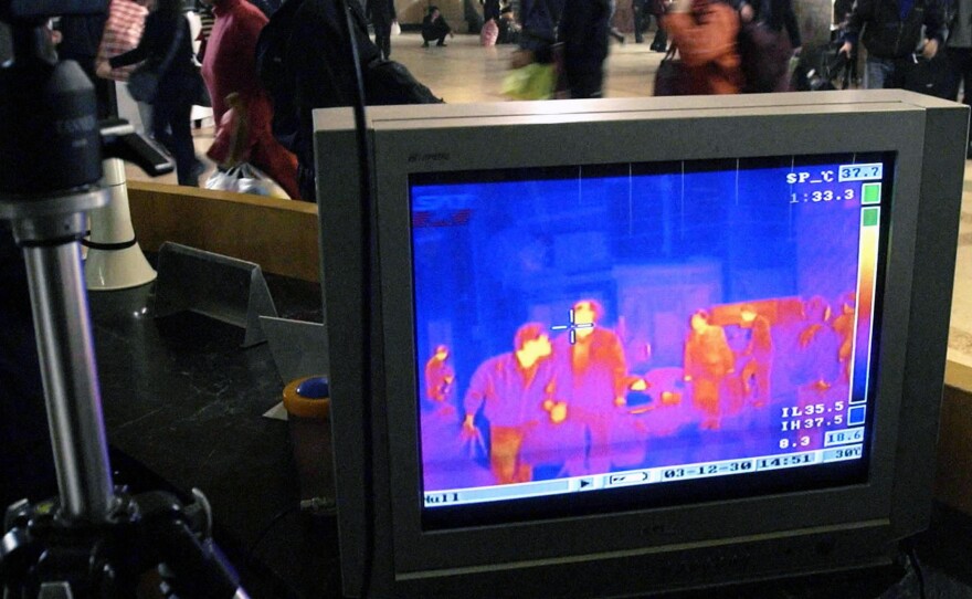 The full-body infrared scanner depicts body temperature with colors on a computer screen. China used the device during the 2003 outbreak of the respiratory virus SARS (pictured, above). Some airports have turned to the scanner as part of Ebola screening.