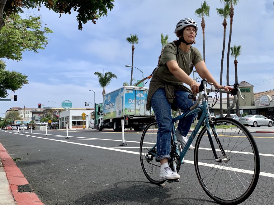A cyclist rides down new protected bike lanes on 30th Street in North Park, July 23, 2021.