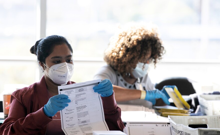 Election workers count Fulton County ballots at State Farm Arena on Nov. 4, 2020 in Atlanta. Falsehoods spread by former President Trump and his allies led to threats against election workers.