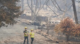Workers with Davey Resource Group asess the damage to the trees in a neighborhood Tuesday, Aug. 25, 2020, in Boulder Creek, Calif.