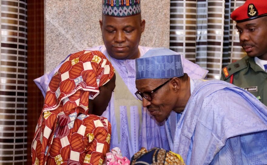 Nigerian president Muhammadu Buhari speaks with freed Chibok schoolgirl Amina Ali Nkeki, who is carrying her baby, as Borno state governor Kashim Shettima (C) looks on in Abuja, on May 19, 2016.