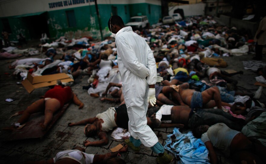 Morgue workers walk among the thousands of bodies piled up at the national hospital in downtown Port-au-Prince after the massive 2010 earthquake.
