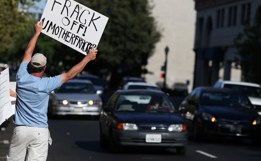 A protestor holds a sign against fracking during a demonstration outside of the California Environmental Protection Agency headquarters on July 25, 2012.