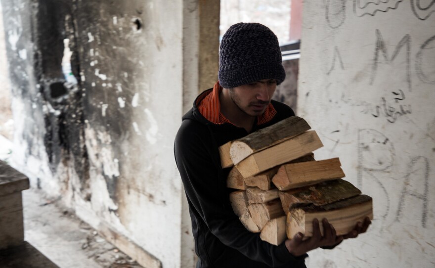 Pakistani Hakim, 21, carries several pieces of wood to the room he occupies with other migrants and refugees in the former Krajina Metal factory in northwest Bosnia-Herzegovina. Improvised fires are the only method people living in squats can use to protect themselves from the cold Balkan winter.