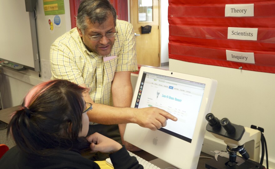 Teacher Jose Rivera-Acosta, in his fifth year in Bethune, helps students in a personal financial literacy class work on a resume for a job interview.