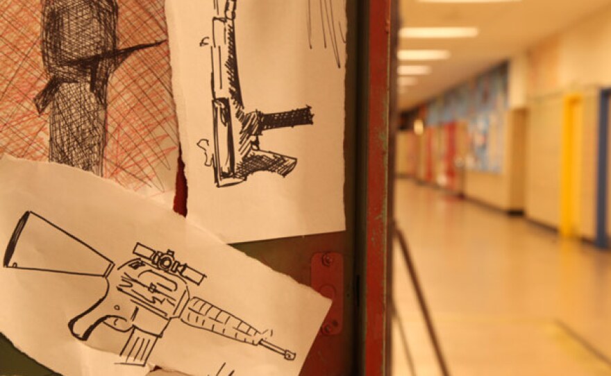 The inside of a locker containing drawings of guns (re-enactment).