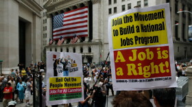 Unemployed workers and other activists protest on the steps of Federal Hall across from the New York Stock Exchange (background) August 12, 2010 in New York, New York.