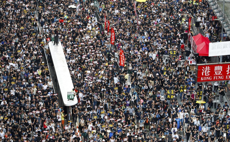 Protesters take part in a march on a street in Hong Kong on Sunday. Thousands of Hong Kong protesters marched from a public park to call for an independent investigation into police tactics.