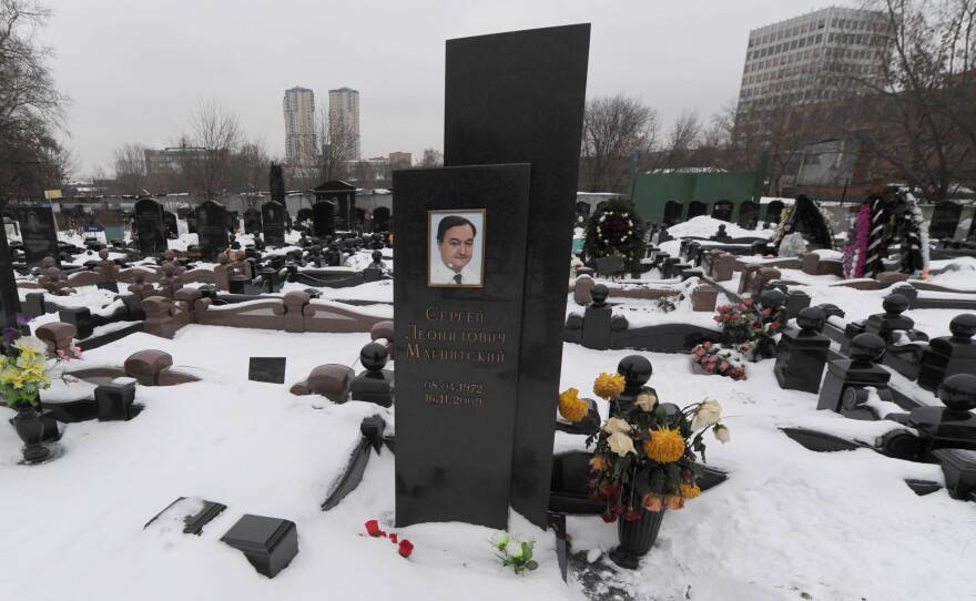 A picture taken on December 7, 2012, shows the snow-clad grave of Russian lawyer Sergei Magnitsky with his portrait on the tomb at a cemetery in Moscow.