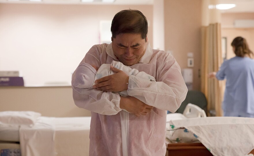 David holds his newborn baby for the first time.