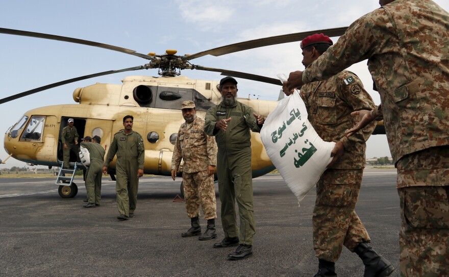 Army soldiers load sacks of food aid on a helicopter to distribute in earthquake-stricken areas in Peshawar, Pakistan, on Tuesday.