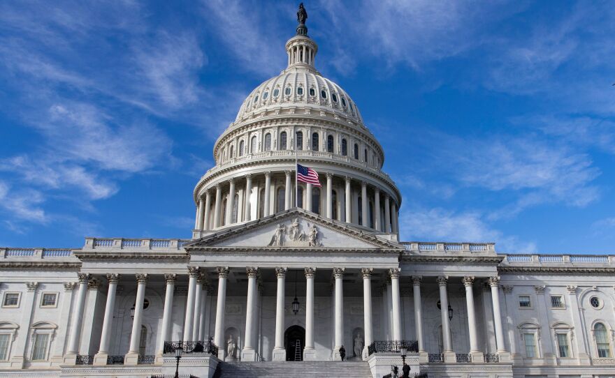 The U.S. flag flies at half-staff in honor of former President George H.W. Bush outside the Capitol in Washington, D.C., Monday. Top Hill leaders planned on a stopgap funding bill to avoid a partial shutdown at the end of the week.