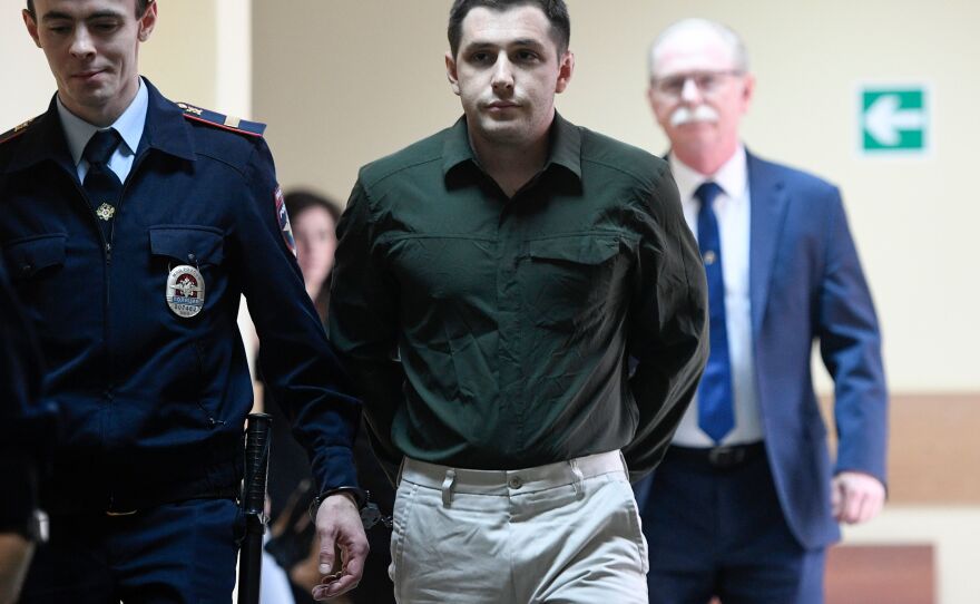 Police officers escort Marine veteran Trevor Reed into a courtroom before a hearing in Moscow on March 11, 2020. In April, Reed was part of a prisoner swap with Russia following a public advocacy campaign by his parents.