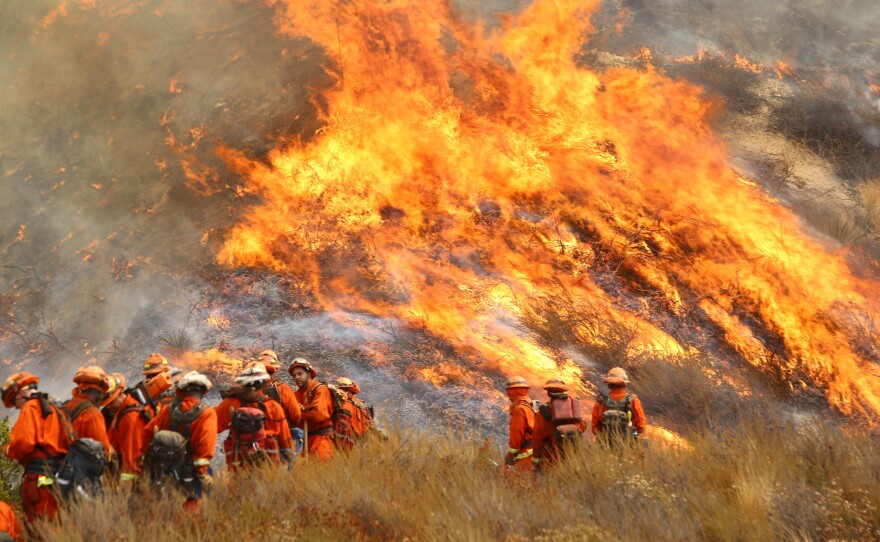 A crew with California Department of Forestry and Fire Protection (Cal Fire) battles "La Tuna" brushfire on the hillside in Burbank, Calif., Saturday, Sept. 2, 2017. 