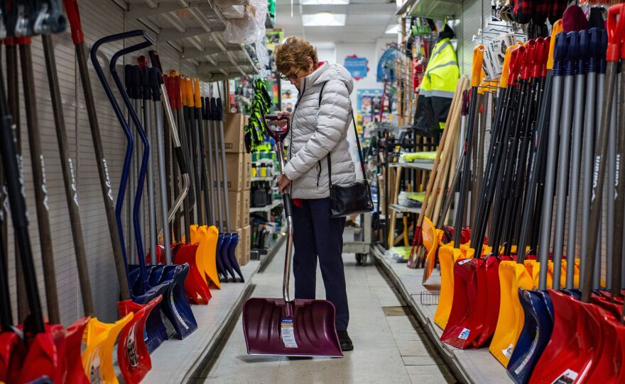 A woman inspects a snow shovel at Woodside Ace Hardware in Winthrop, Mass., on Friday as people prepare for the oncoming nor'easter. The storm is expected to bring blizzard conditions and 18-24 inches of snow to the region as well as some flooding.