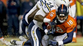 Denver Broncos quarterback Peyton Manning, right, is sacked by San Diego Chargers outside linebacker Melvin Ingram during the second half in an NFL football game in Denver, Jan. 3, 2016. 