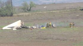 Firefighters look at debris from a mid-air plane crash, Aug. 17, 2015.