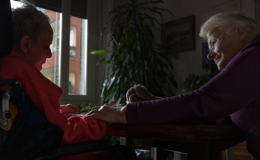Caregiver Vira Zhmurko (right) holds Anna's hand in Milan in November 2023. Vira had come to Italy a few days before Feb. 24, 2022, to substitute for a friend who had to return to Ukraine. However, after the war broke out, Vira found herself stuck as her city was being bombed by Russia.